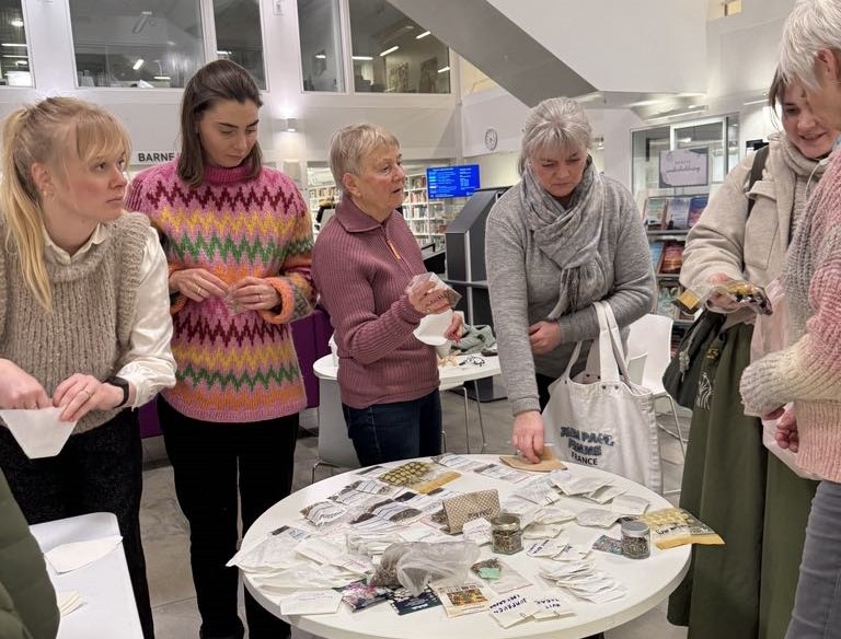 Frøbyttekveld på Tangvall Bibliotek. Praten går livlig om de ulike frøene som lå klare for å skifte eier i løpet av kvelden.