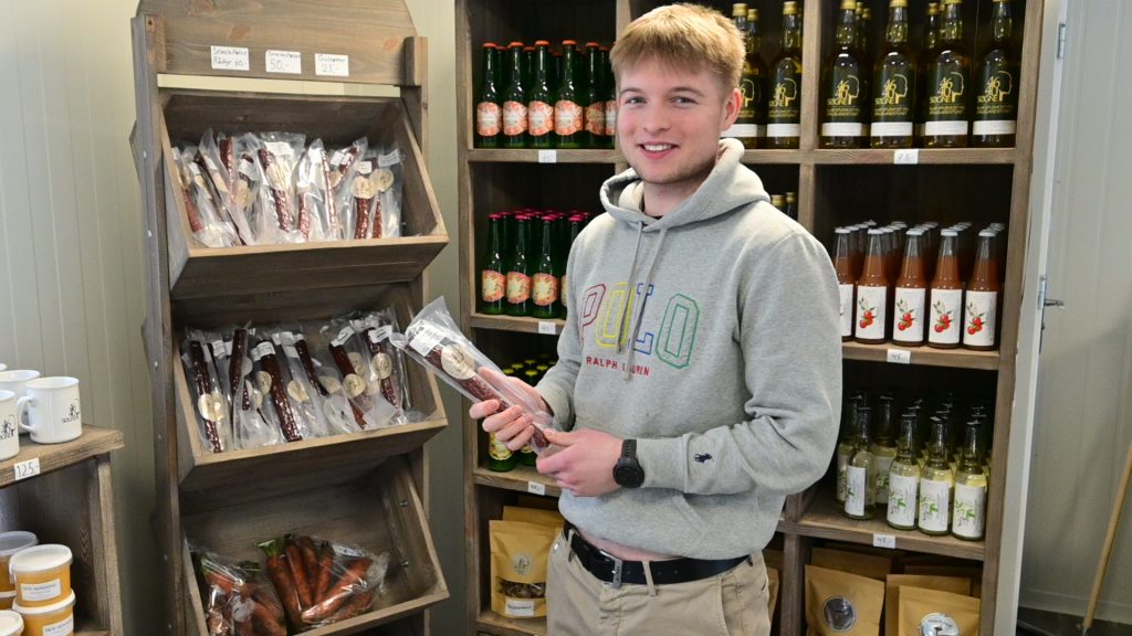 Toralv Pettersen viser en lokalprodusert pølse fra Slakteren i Søgne.