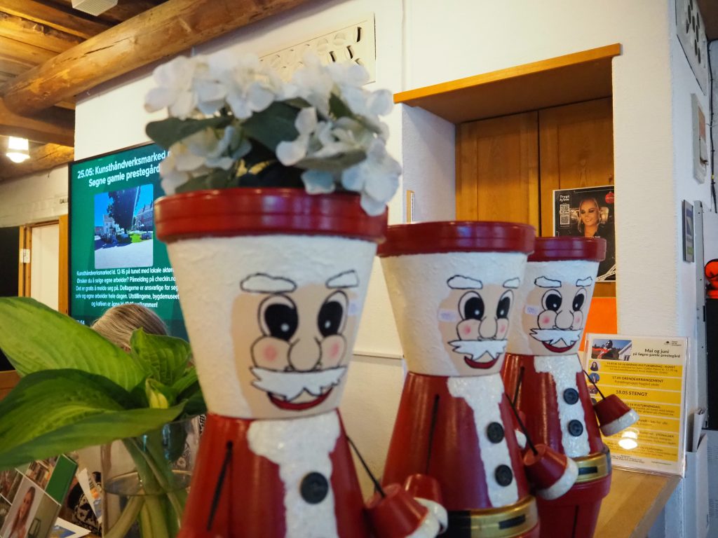Terrakottapotter er satt oppå hverandre og blitt til festlige nisser.