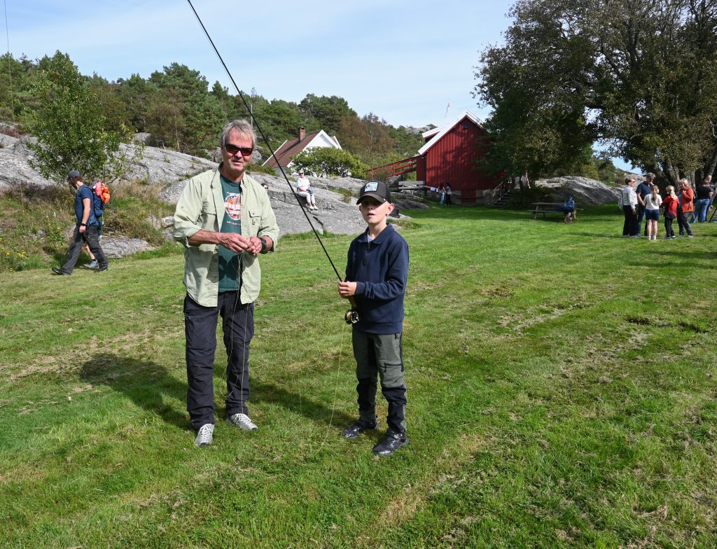 Flott familiedag i Helleviga og Romsviga! 4 Stein Grønberg fra Kristiansand Jeger og Fiskeforening viser Konrad Larsen fluefiske.