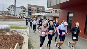 Glade løpere på vei gjennom Tangvall sentrum.