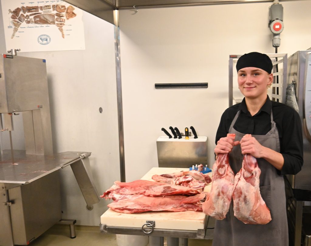 Julemat hos Slakteren i Søgne 2 Datteren til Elise, Janne Holmen holder lammelårene som skal legges i disken. De kuttes opp og selges som fårikål.